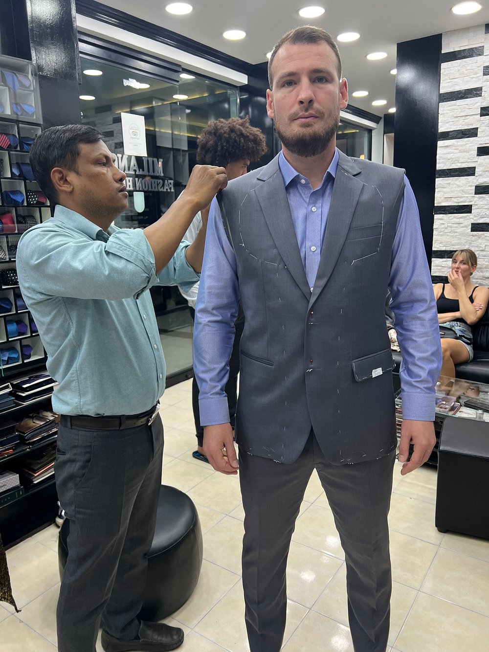 Sanjay, master tailor at Milano Fashion House, hand-pinning a client's waistcoat during a fitting